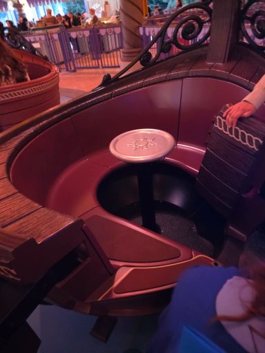 Vehicle interior A circular seating area with a central table in a themed attraction.