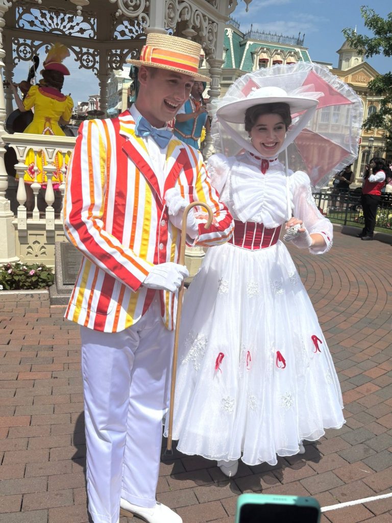 Mary Poppins and Bert in their jolly holiday outfits in town square