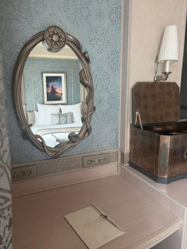 Elegant room featuring a vintage mirror and a decorative trunk on a wooden table.