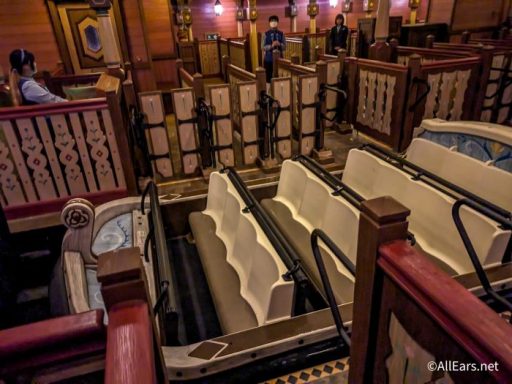 Interior view of a vintage amusement ride with seating benches and wooden decor.