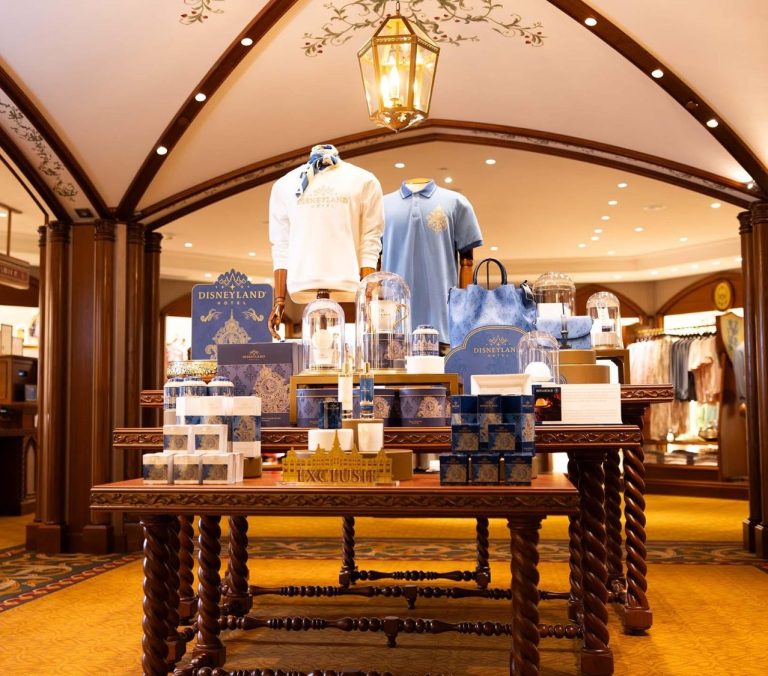 Display of blue apparel and gift items in an elegant retail setting.