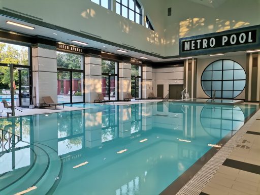 Indoor swimming pool with large windows and retro design elements.