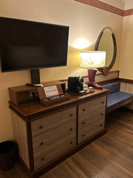Dresser area and TV a hotel tv and dresser with a cowboy boot themed lamp