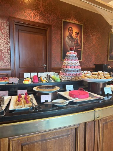 A lavish dessert display featuring tiered cakes, pastries, and colourful treats.