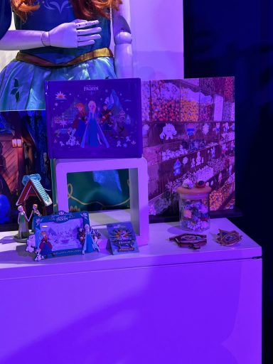 Collection of animated character figurines and framed artwork displayed on a shelf.