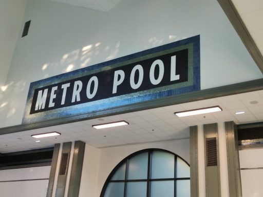 Sign for "METRO POOL" displayed on a wall in an indoor facility.
