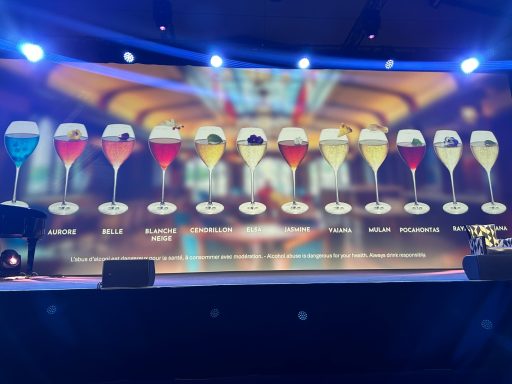 A variety of cocktails displayed on a bar, with vibrant colours and different glass types.