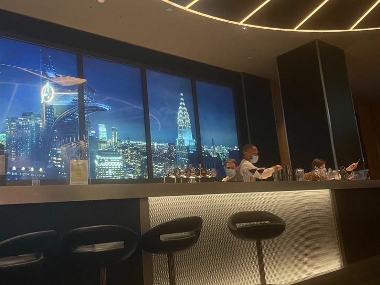 Two refreshing cocktails on a table, with a view of the lake outside.