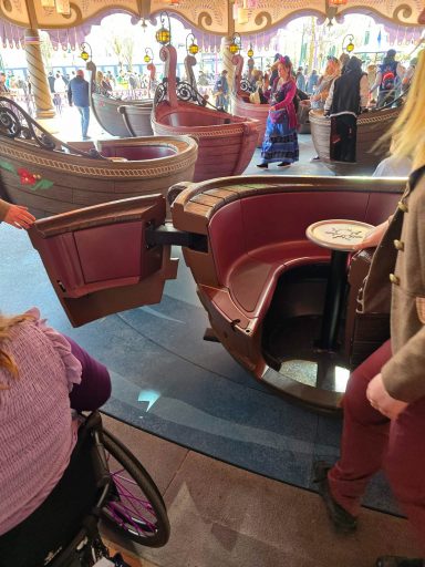 Wider door A carousel with accessible seating for visitors in a colourful amusement park setting.