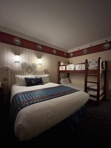 Accessible room - beds Cozy hotel room featuring a double bed and a bunk bed against textured wallpaper.