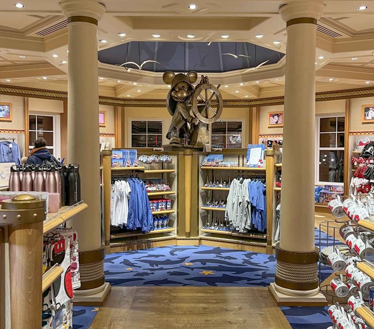 Interior of a retail store with shelves displaying merchandise and a decorative sailor Mickey statue.