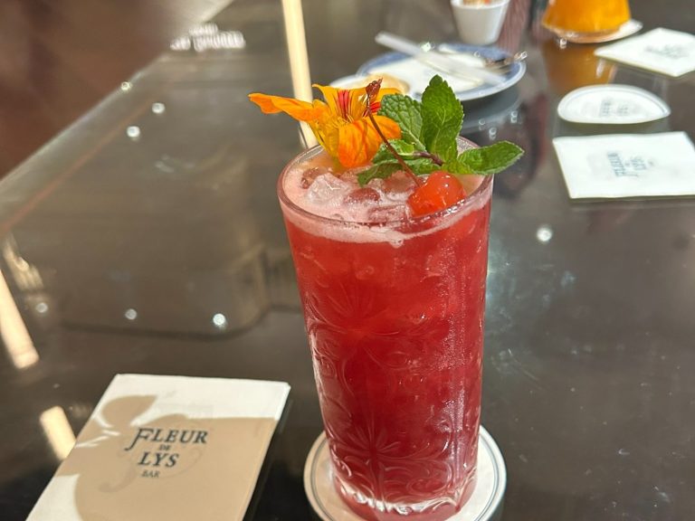 Two refreshing cocktails on a table, with a view of the lake outside.