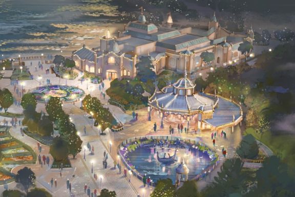 Aerial view of a vibrant amusement park with a carousel and illuminated buildings.