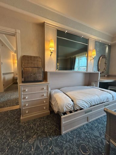 A stylish bedroom featuring a foldable bed, large mirror, and elegant decor.